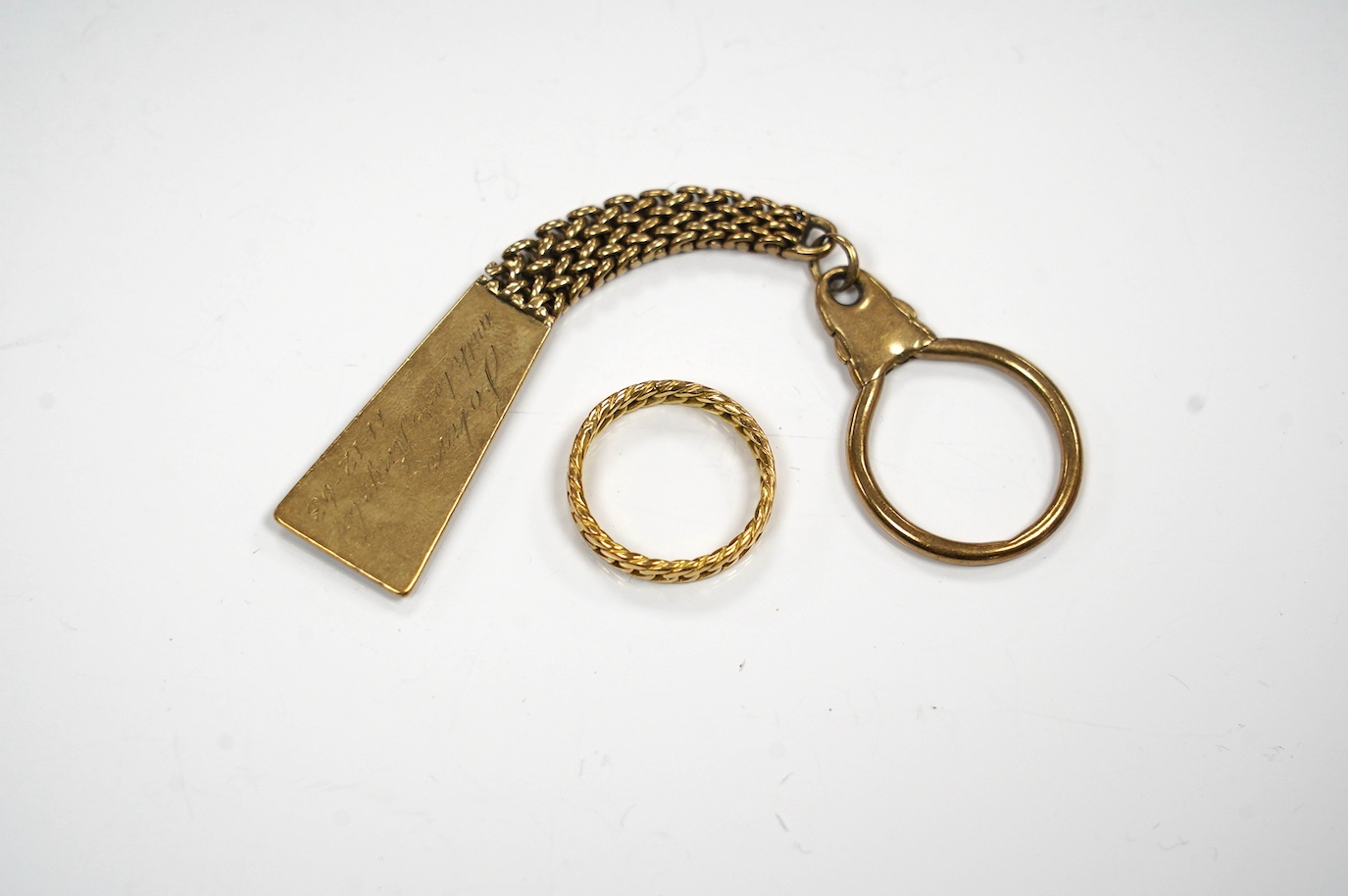 A 9ct gold key chain, with engraved inscription and a yellow metal band, gross weight 17.2 grams. Condition - fair